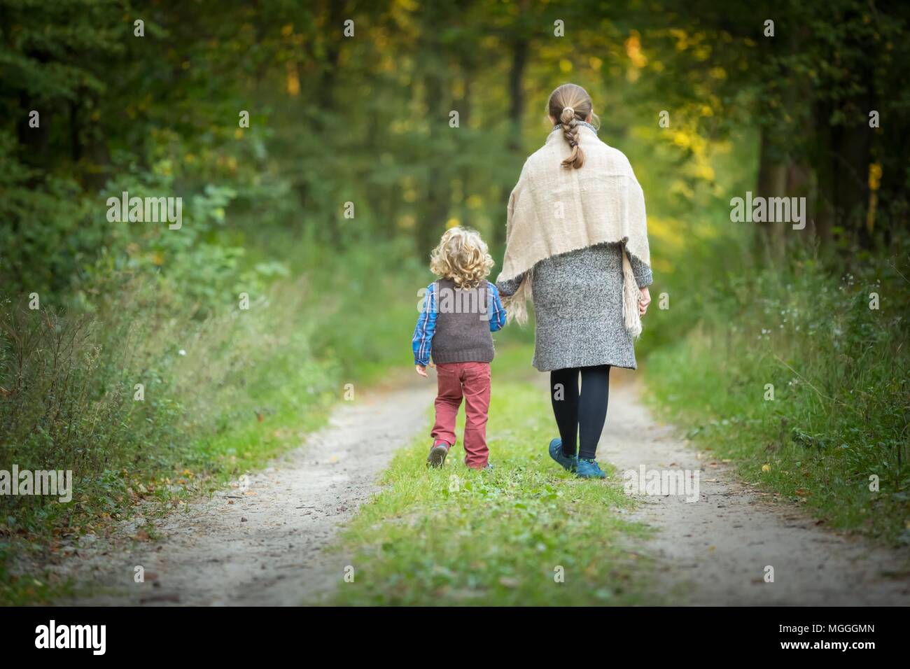 Madre e figlio insieme nella foresta. Famiglia nella foresta autunnale. Foto Stock