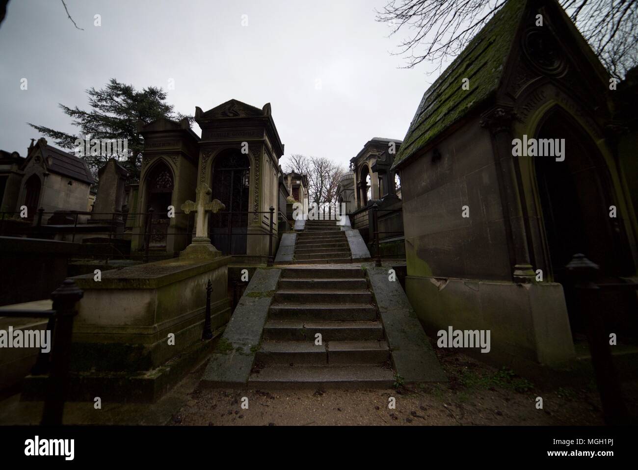 Sentiero / strada attraversando Père Llachaise cimitero di Parigi con un sacco di tombe e lapidi. Foto Stock