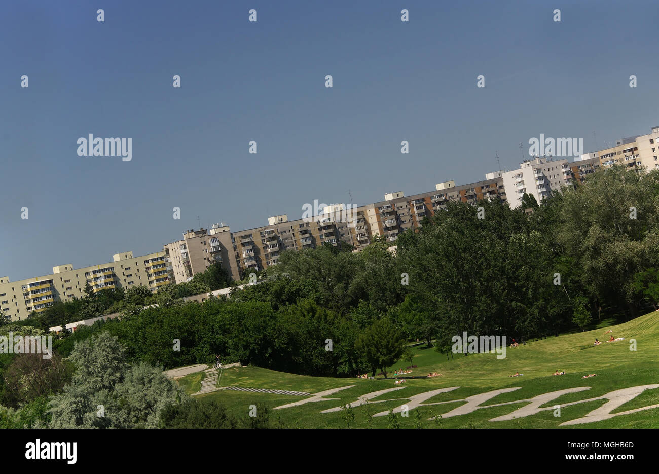 Bucarest, Romania,giugno 7,2015:angolo olandese su Titan Park con persone lontane a prendere il sole sul prato, appartamenti skyline di edifici Foto Stock