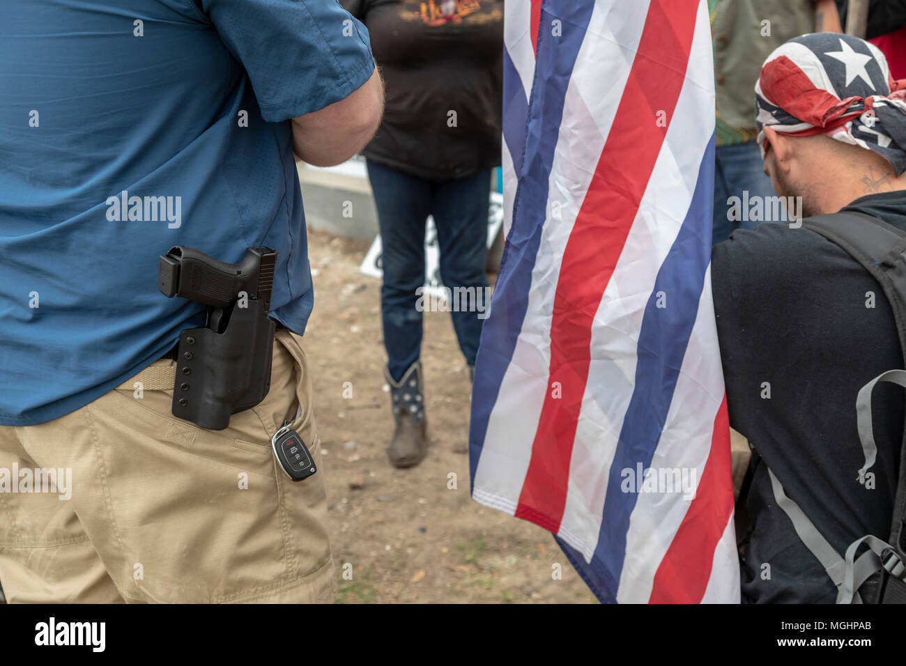 New Orleans, Louisiana - trasportare varie bandiere Confederate, un piccolo gruppo, alcuni di loro armati, prega presso il sito in cui una statua di Jefferson Davis wa Foto Stock