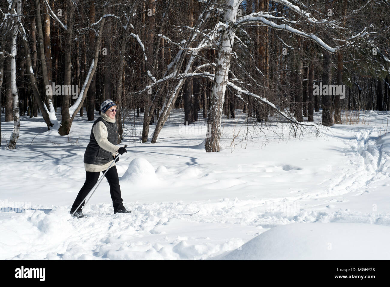 UFA, Russia 29marzo 2018 - Anziani donna che indossa gli sport invernali abbigliamento sci di fondo attraverso una pista forestale in nevicata utilizzando l'inverno sp Foto Stock