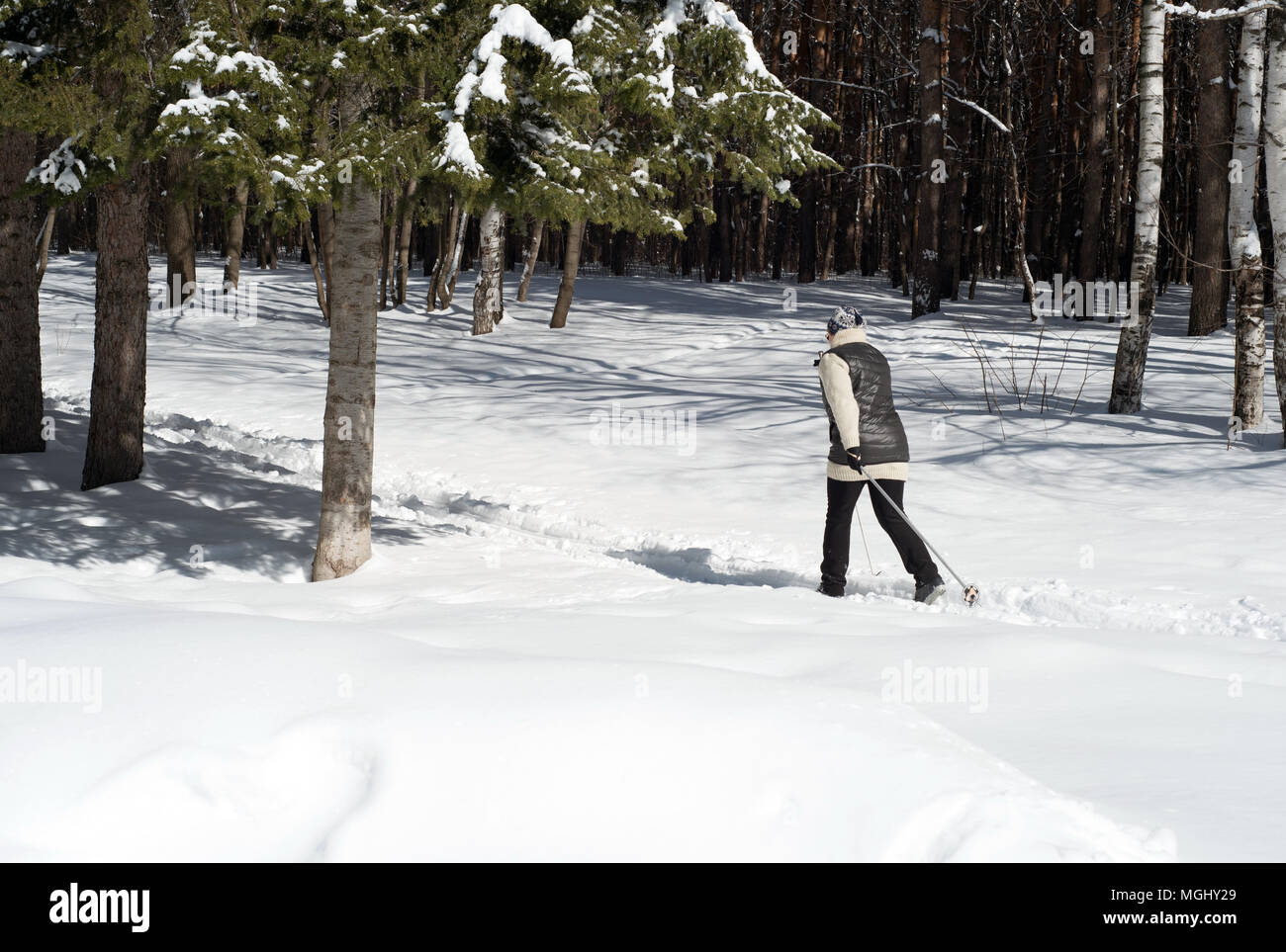 UFA, Russia 29marzo 2018 - Anziani donna che indossa gli sport invernali abbigliamento sci di fondo attraverso una pista forestale in nevicata utilizzando l'inverno sp Foto Stock