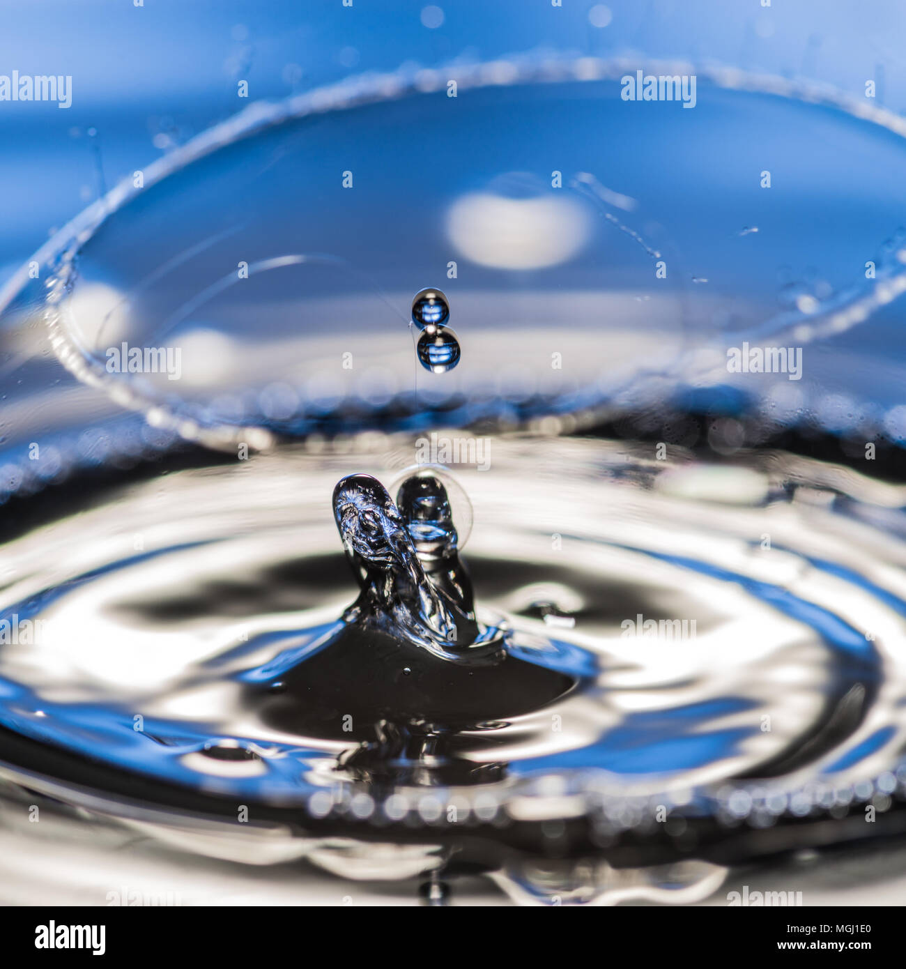 La caduta di gocce di acqua scoppiare una bolla di sapone. Foto Stock