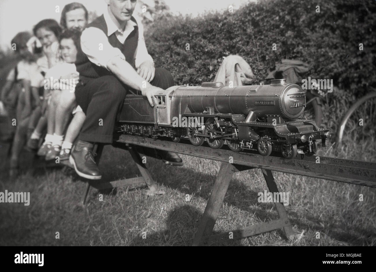 Degli anni Cinquanta, storiche, i bambini a cavallo di un treno su una ferrovia in miniatura, Inghilterra, Regno Unito. Foto Stock