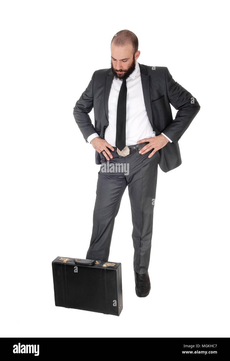 Un giovane bello business man standing, guardando all uomo di pensare con la sua borsa ai suoi piedi, isolato per sfondo bianco Foto Stock