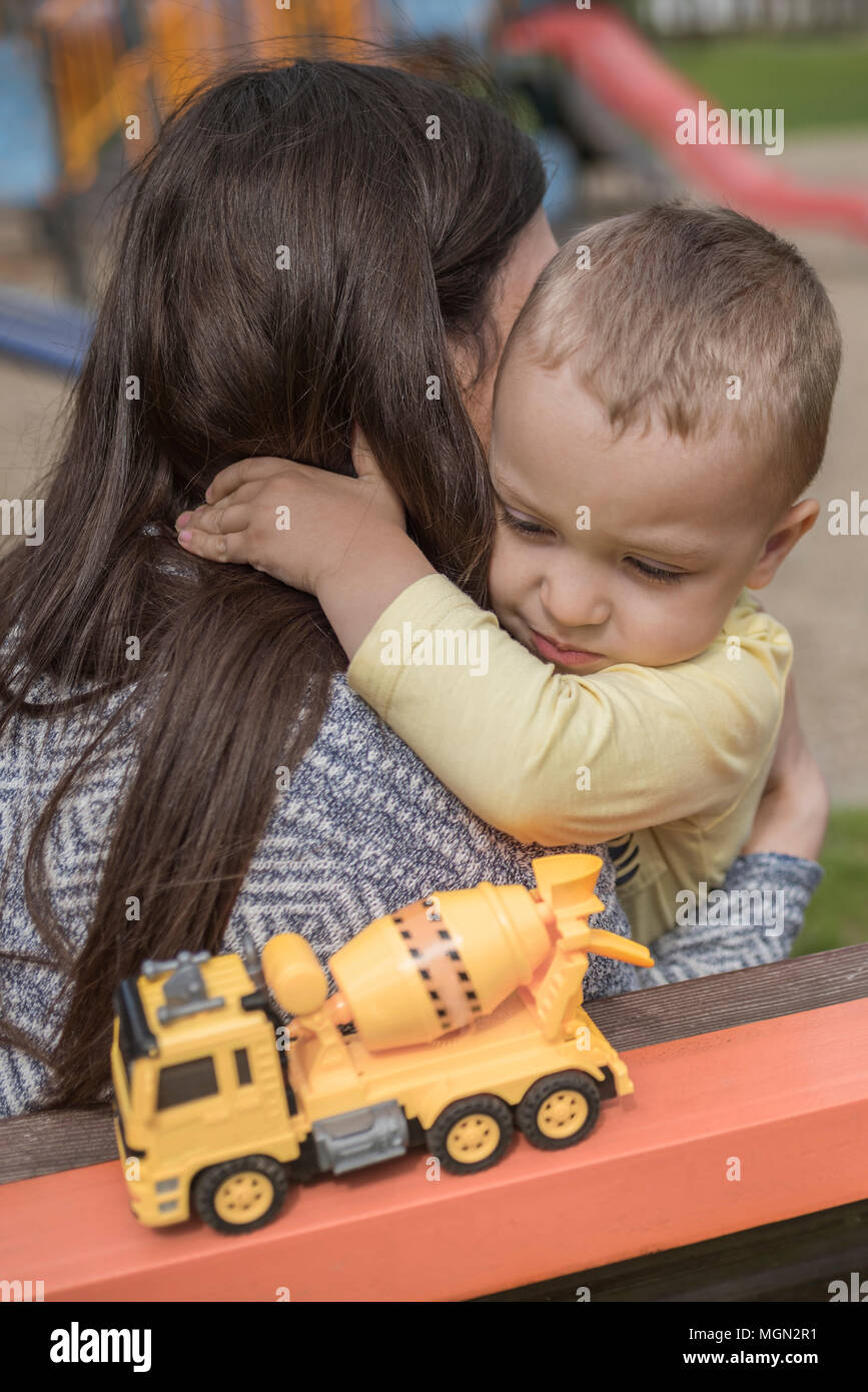 Closeup ritratto di un felice la madre e il figlio a giocare sul campo giochi e divertimento. Giovane madre gioca con il suo bambino al di fuori nel parco. Madre e figlio. Foto Stock