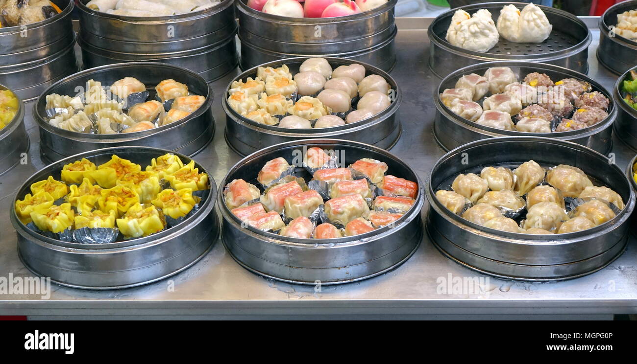 Un venditore ambulante vende Cantonese Dim Sum piatti cucinati in vaporizzatori metallici Foto Stock