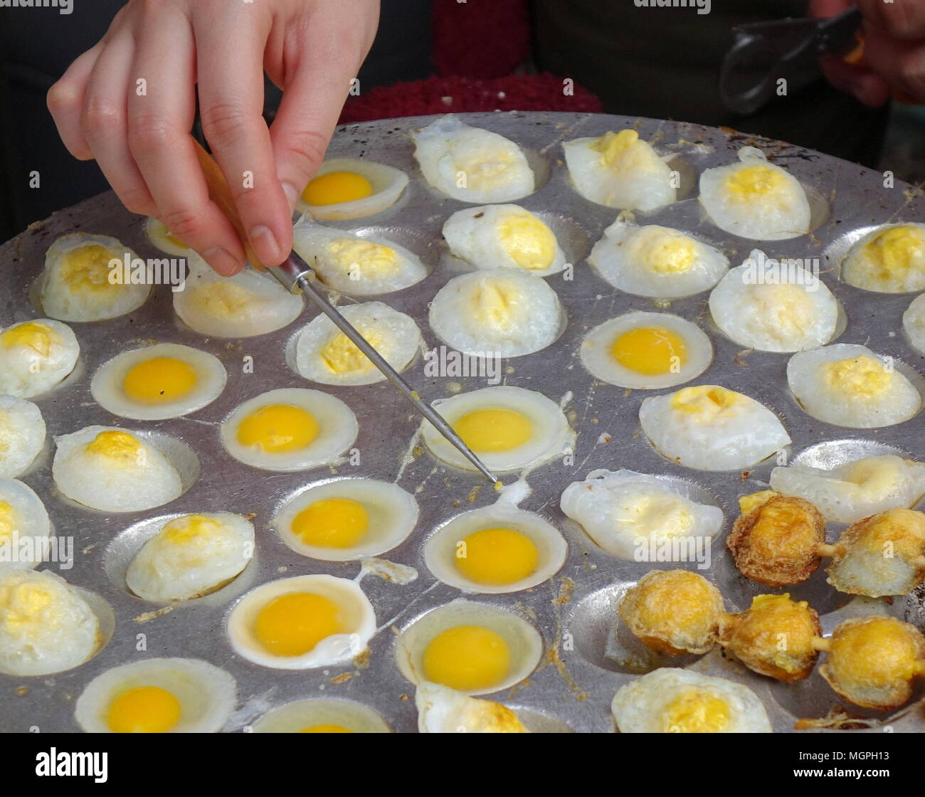 Un venditore ambulante cuochi scottata di uova di quaglia, un popolare snack in Taiwan Foto Stock