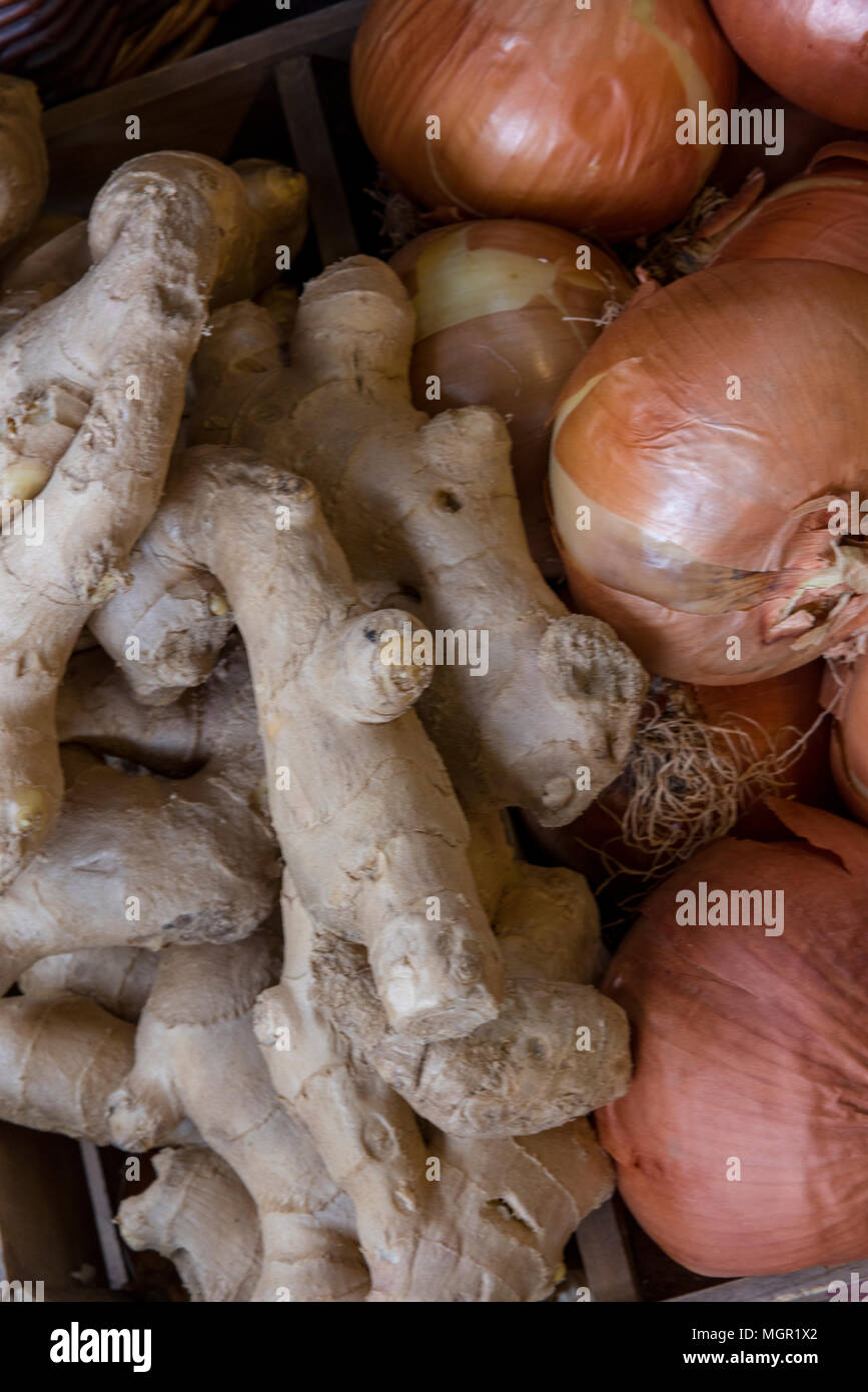 Di zenzero fresco e rosolare le cipolle in vendita presso un fruttivendolo stallo in Borough Market nel centro di Londra. Buon cibo e prodotti biologici in un mercato. Foto Stock