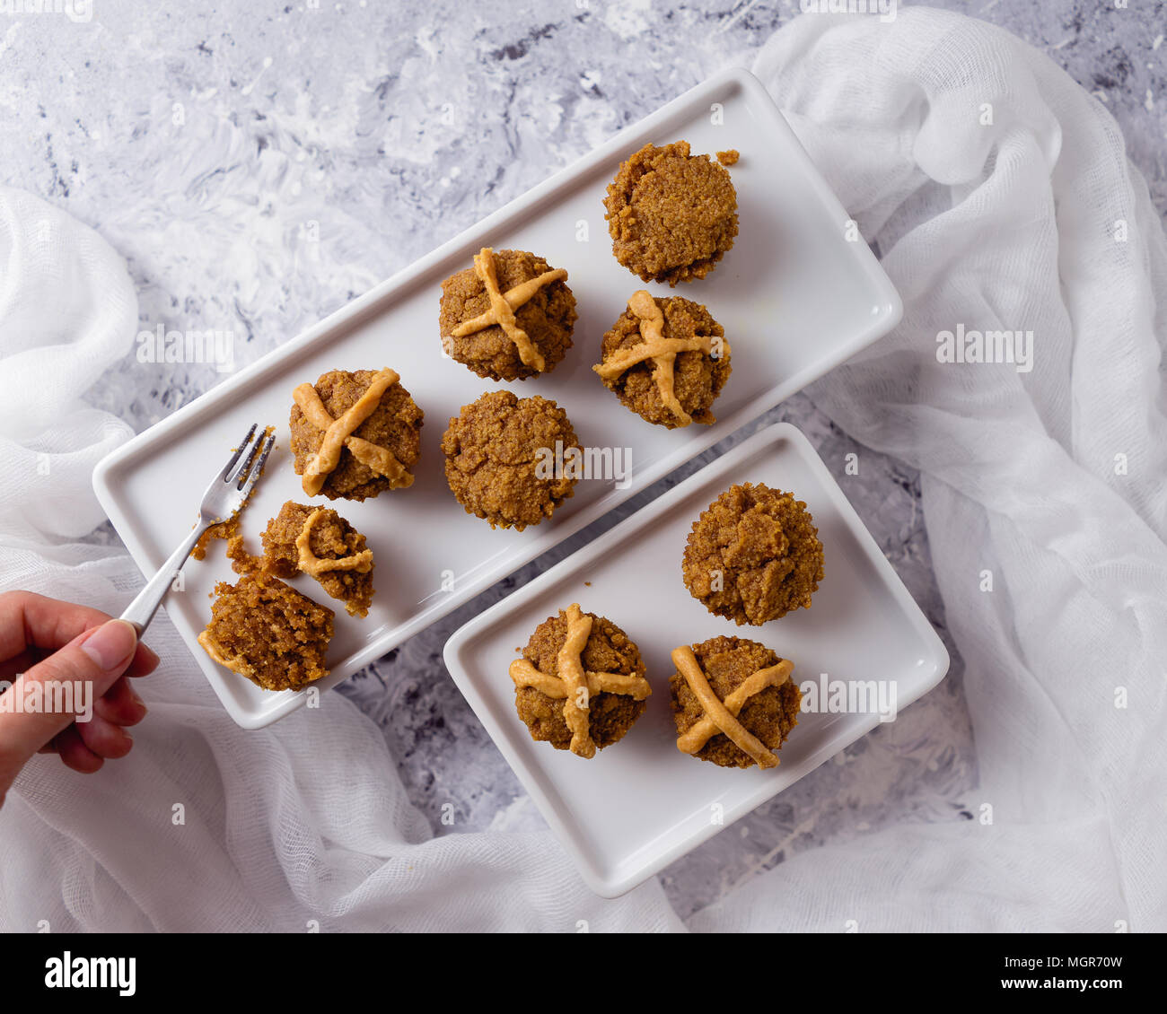 Hot Cross muffin per la Pasqua, illuminate della scena della tabella Foto Stock