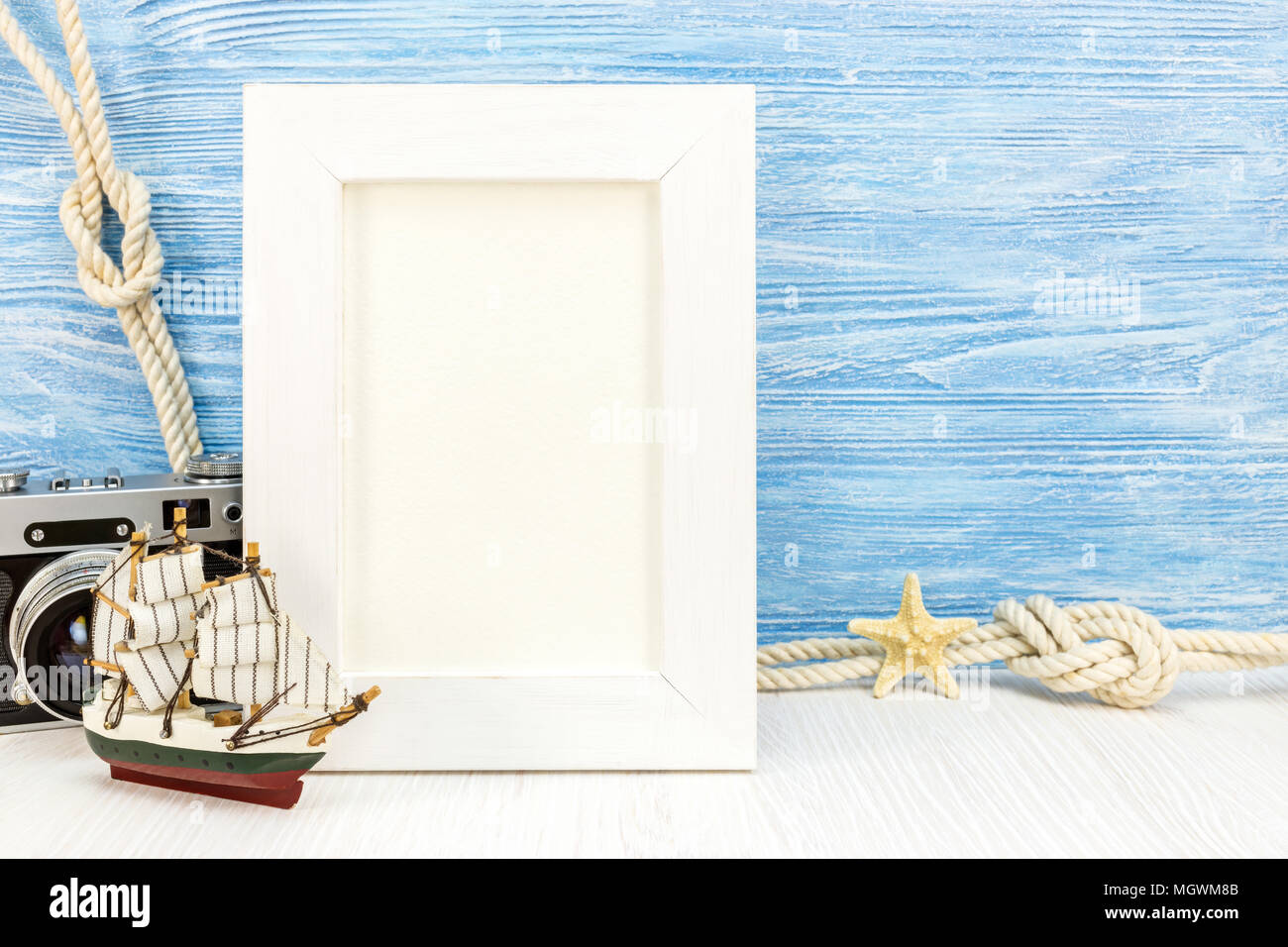 Svuotare il photo frame blu su sfondo di legno con stelle marine, nave, marine nodi, classic camera. vacanze estate concept Foto Stock
