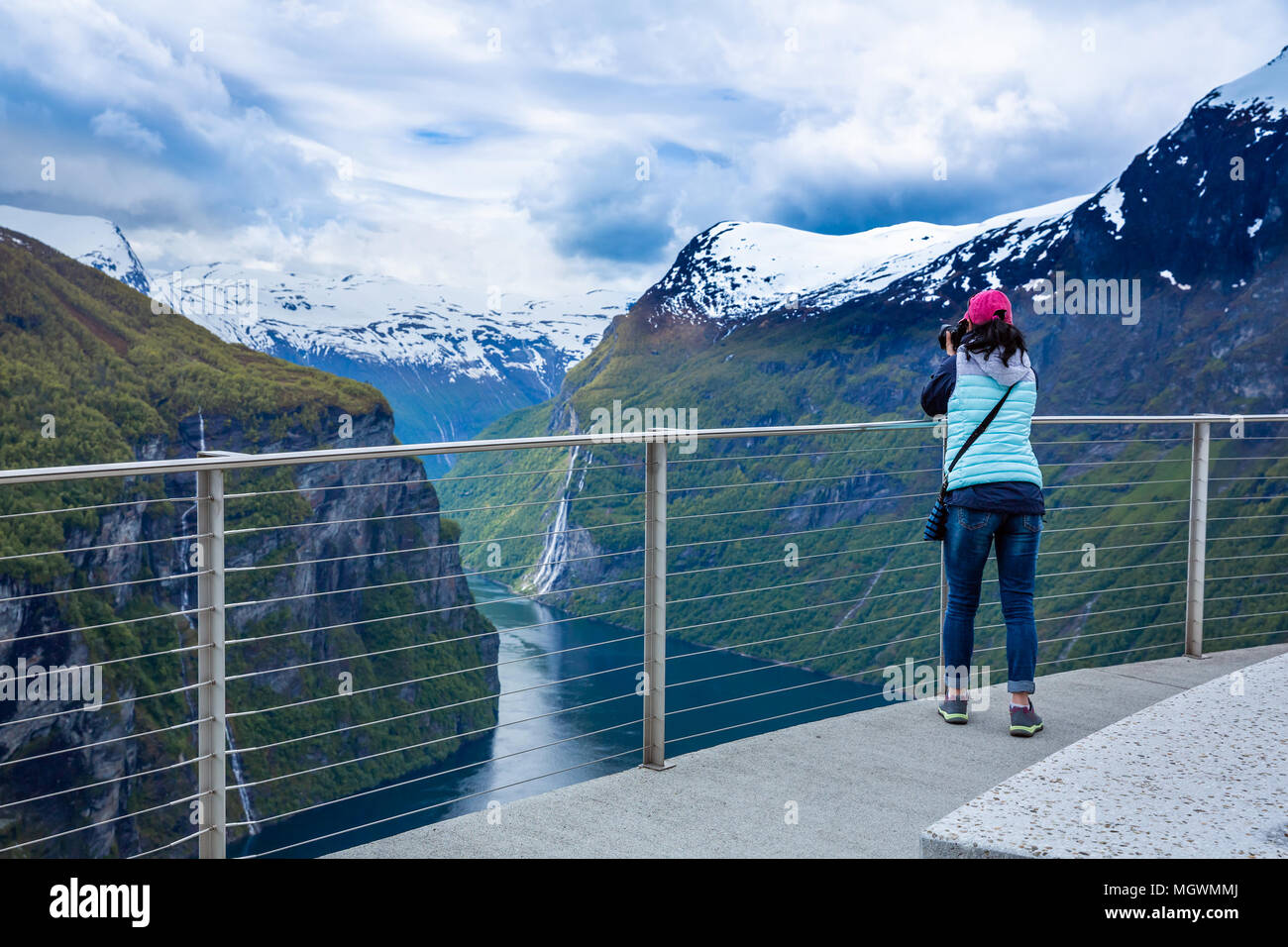 Fotografo di natura turistico con fotocamera germogli mentre si sta in piedi sul belvedere Geiranger fjord, la bellissima natura della Norvegia. Foto Stock