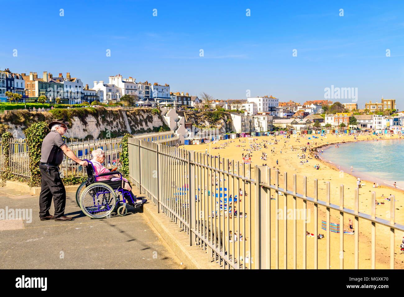 Anziani disabili donna in carrozzella con accompagnatore che si affaccia sulla spiaggia di viking bay broadstairs Foto Stock