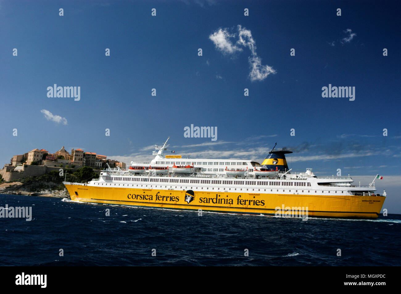 Un passeggero/ traghetto per auto, Corsica ferries e Sardinia Ferries in avvicinamento al porto di Calvi in Corsica come vele passato la cittadella di Calvi su una collina. Th Foto Stock