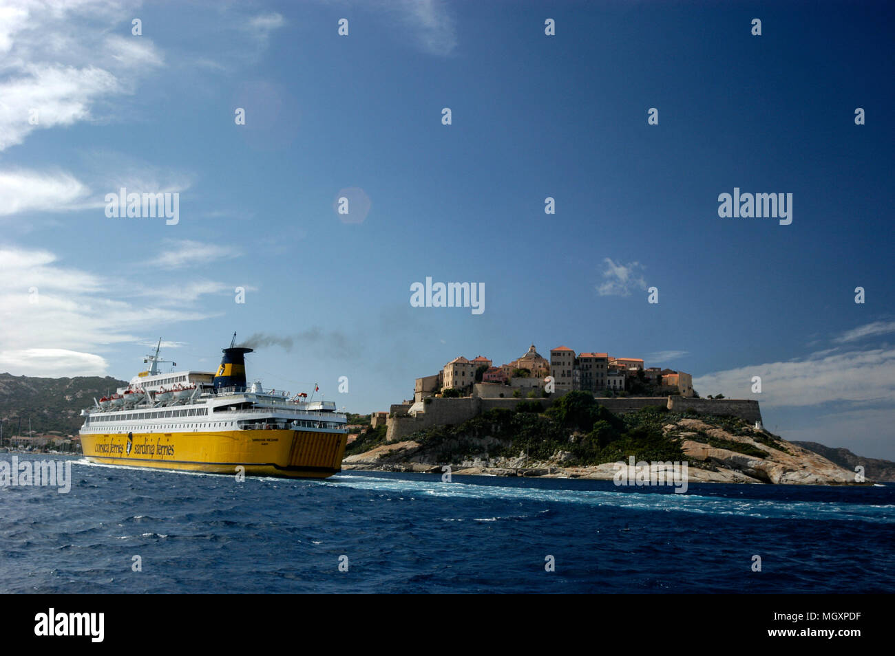 Un passeggero/ traghetto per auto, Corsica ferries e Sardinia Ferries in avvicinamento al porto di Calvi in Corsica come vele passato la cittadella di Calvi su una collina. Th Foto Stock