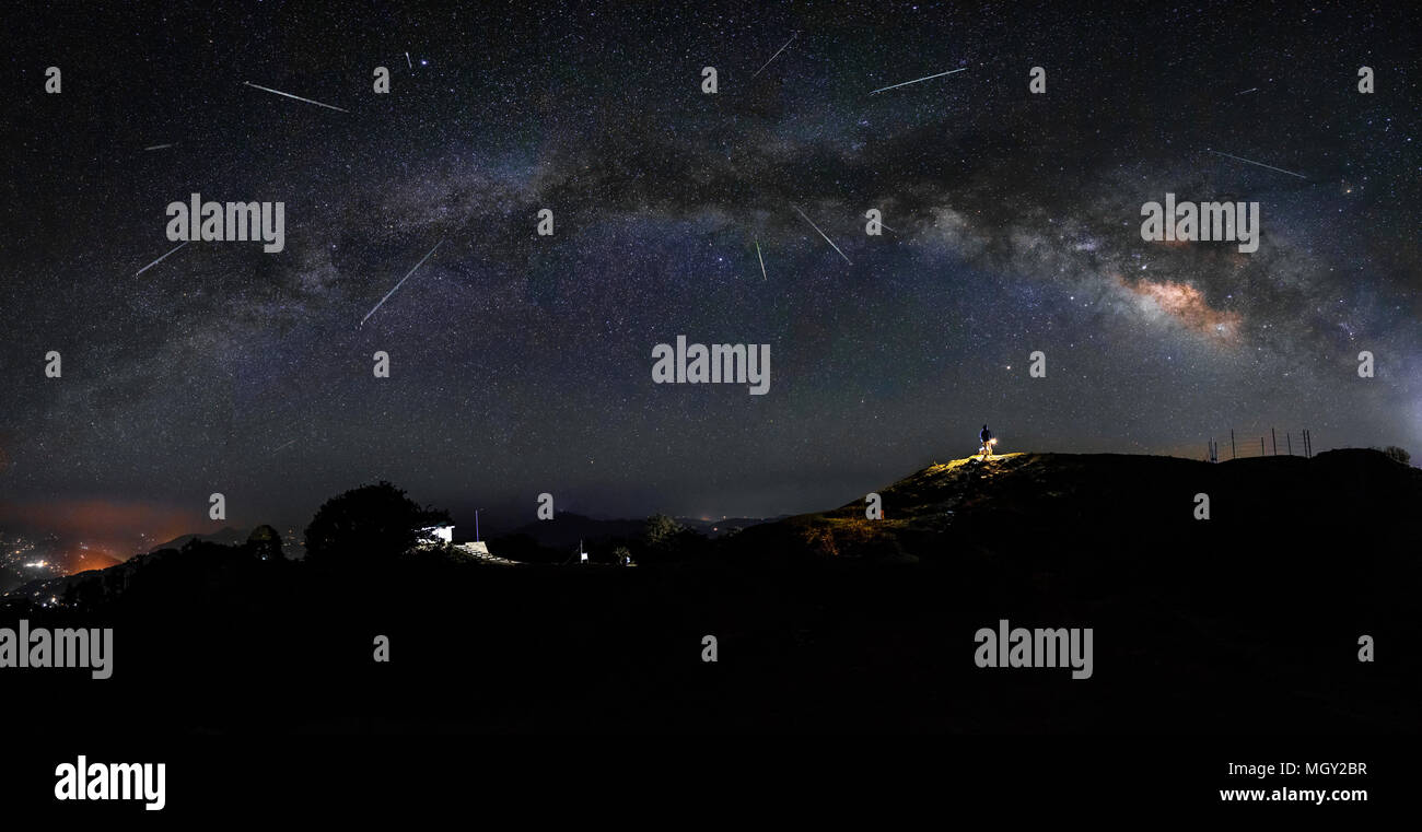 Lyrids Meteor doccia con il panorama della via lattea teso attraverso il cielo sulla sommità del picco Hatu, Shimla Foto Stock