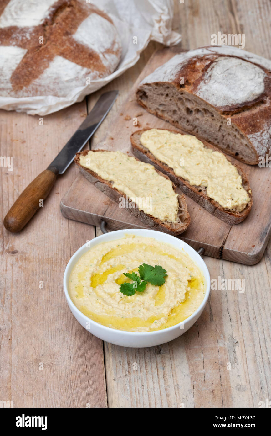 Pane e farina di farro con hummus fatto in casa su una tavola di pane. REGNO UNITO. Foto Stock