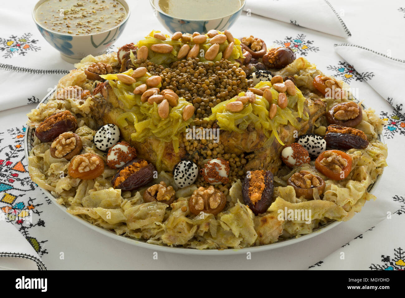 Festive Marocchino tradizionale Rfissa servito con salsa e decorared con uova di quaglia, semi, frutta e noci Foto Stock