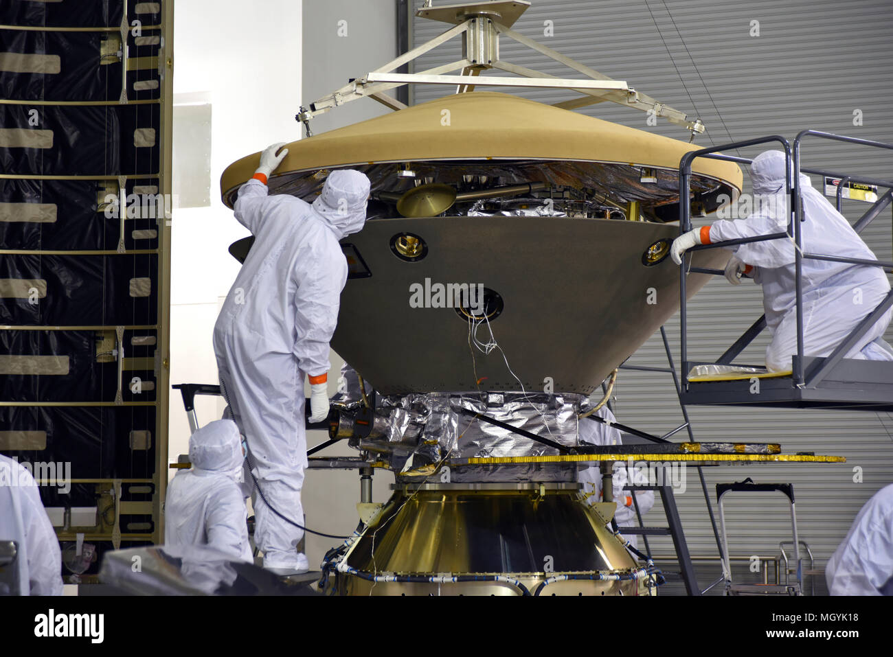 Nella struttura Astrotech tecnici ed ingegneri posizionare il heatshield su Marte della NASA Lander InSight prima dell'incapsulamento in suo payload carenatura presso la base aerea di Vandenberg Space Launch Complex 3 Aprile 12, 2018 in Lompoc, California. L'intuizione che sta per indagini sismiche, geodesia e trasporto di calore, sarà la prima missione a guardare in profondità sotto la superficie marziana ed è previsto per il decollo del 5 maggio 2018. Foto Stock