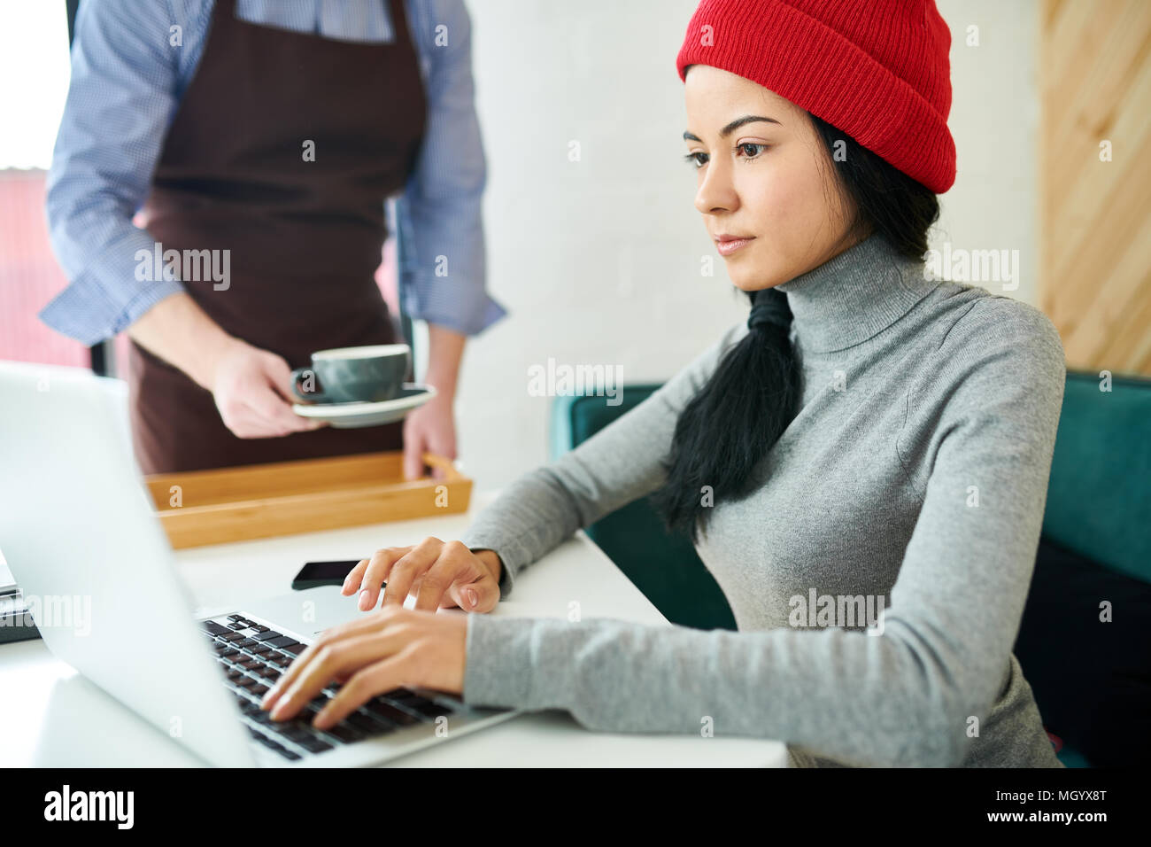 Moderno e giovane donna utilizzando laptop in Cafe Foto Stock