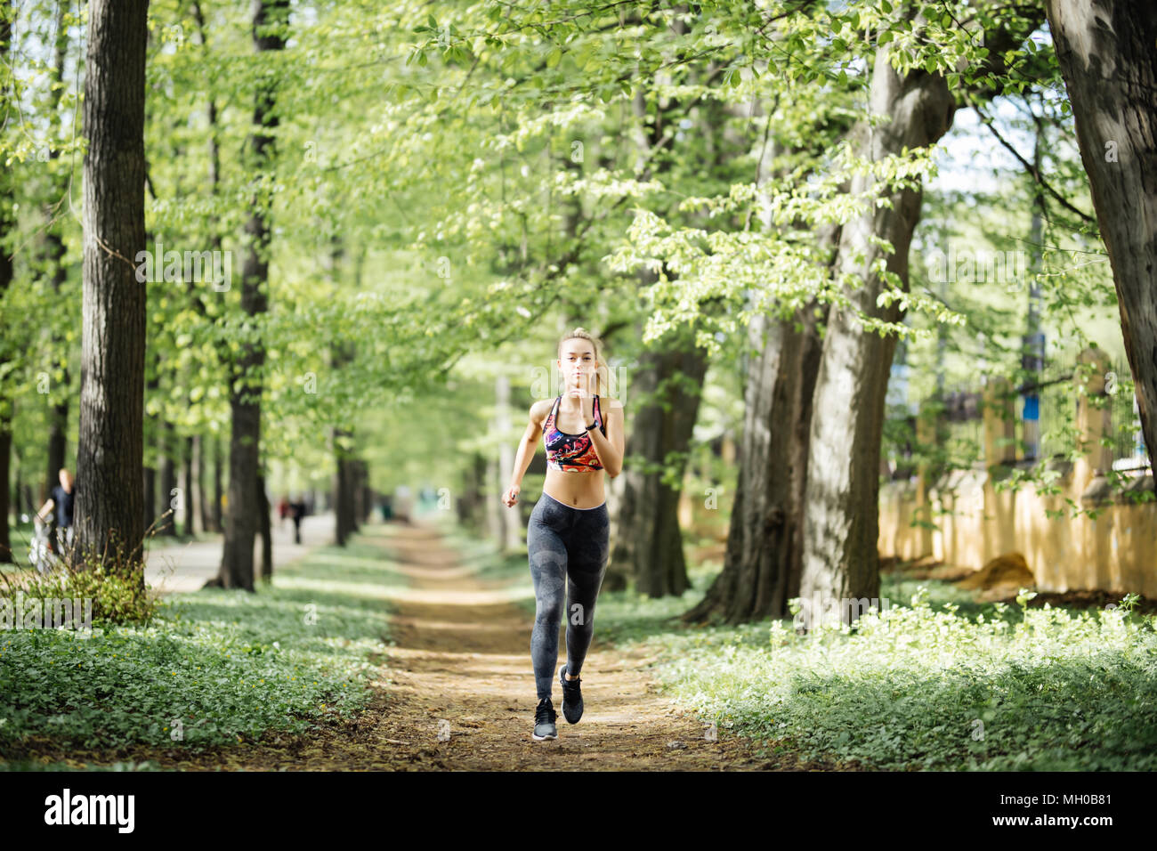 Runner atleta che corre al parco cityl. donna jogging fitness workout concetto di benessere. Foto Stock