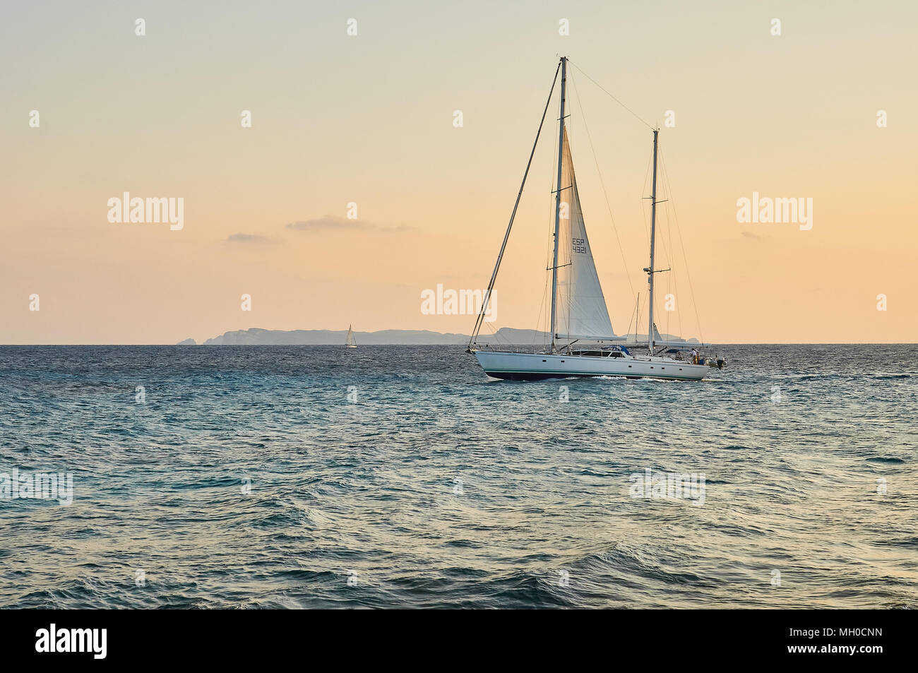 Barca a vela al tramonto e Arcipelago di Cabrera sullo sfondo da Capo Cap de Ses Salines a Maiorca (Isole Baleari, Mar Mediterraneo, Spagna) Foto Stock