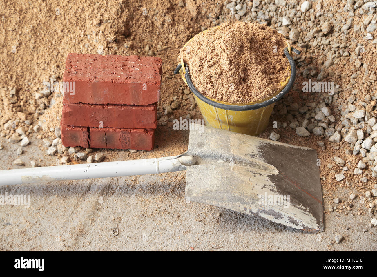 Materiale da costruzione quali sabbia e ghiaia, pala, benna hoe, cemento e  mattoni Foto stock - Alamy