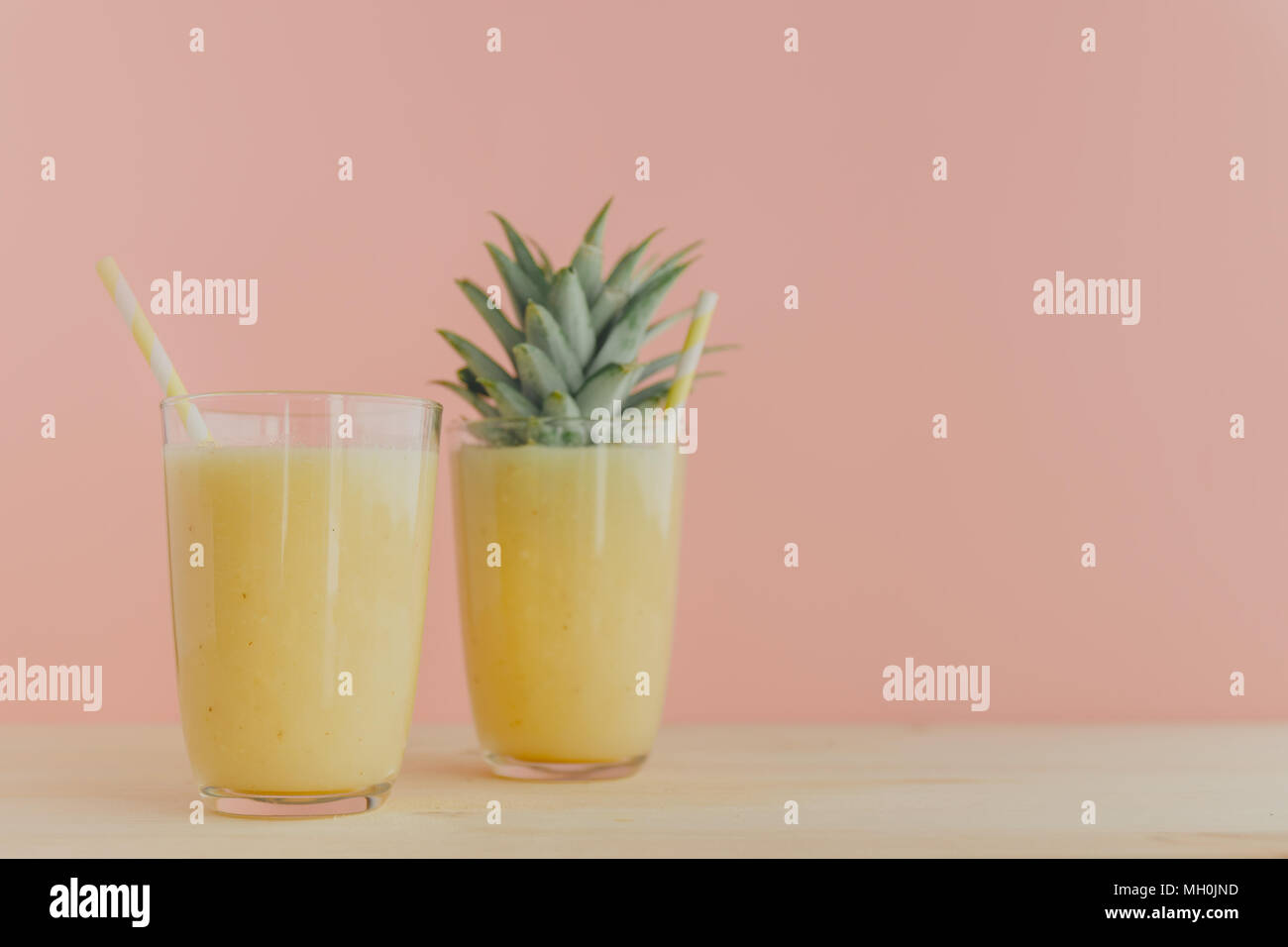 Due bicchieri riempiti con appena fatti Frullato di ananas e servite con cannucce colorate. Foto Stock