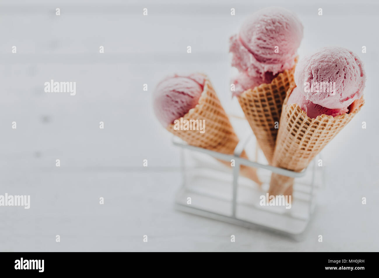 Primo piano di pochi cialda croccante di coni con palline di rosa di gelati in appositi stand. Foto Stock