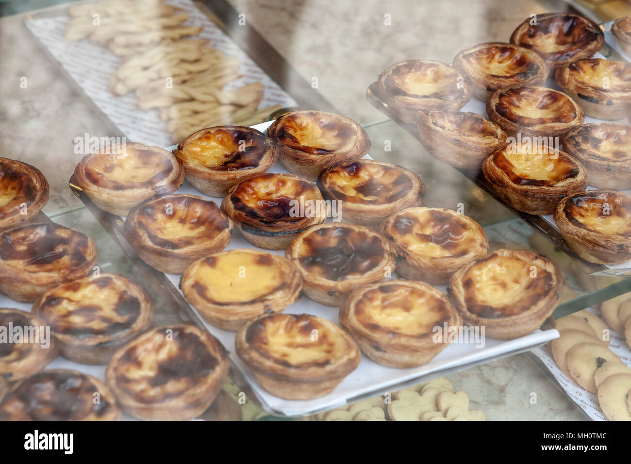 Il portoghese crema pasticcera crostate, chiamato 'Pastel de nata o de Belem' nell'vitrine Foto Stock