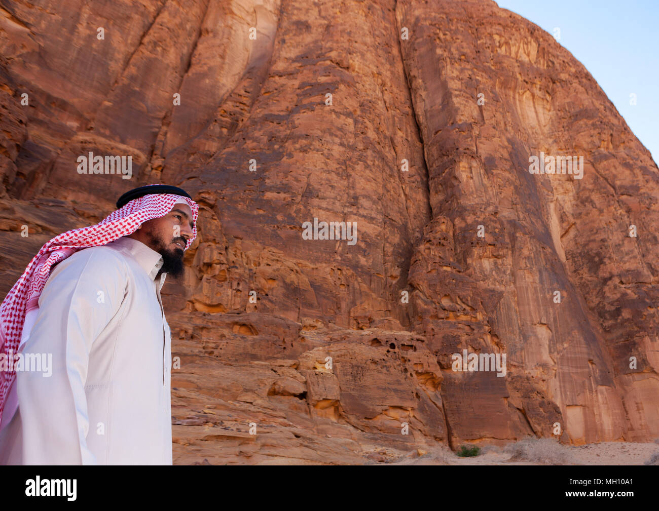 Arabia uomo di fronte a un colle di madain saleh sito archeologico, Al Madinah Provincia, Al-Ula, Arabia Saudita Foto Stock