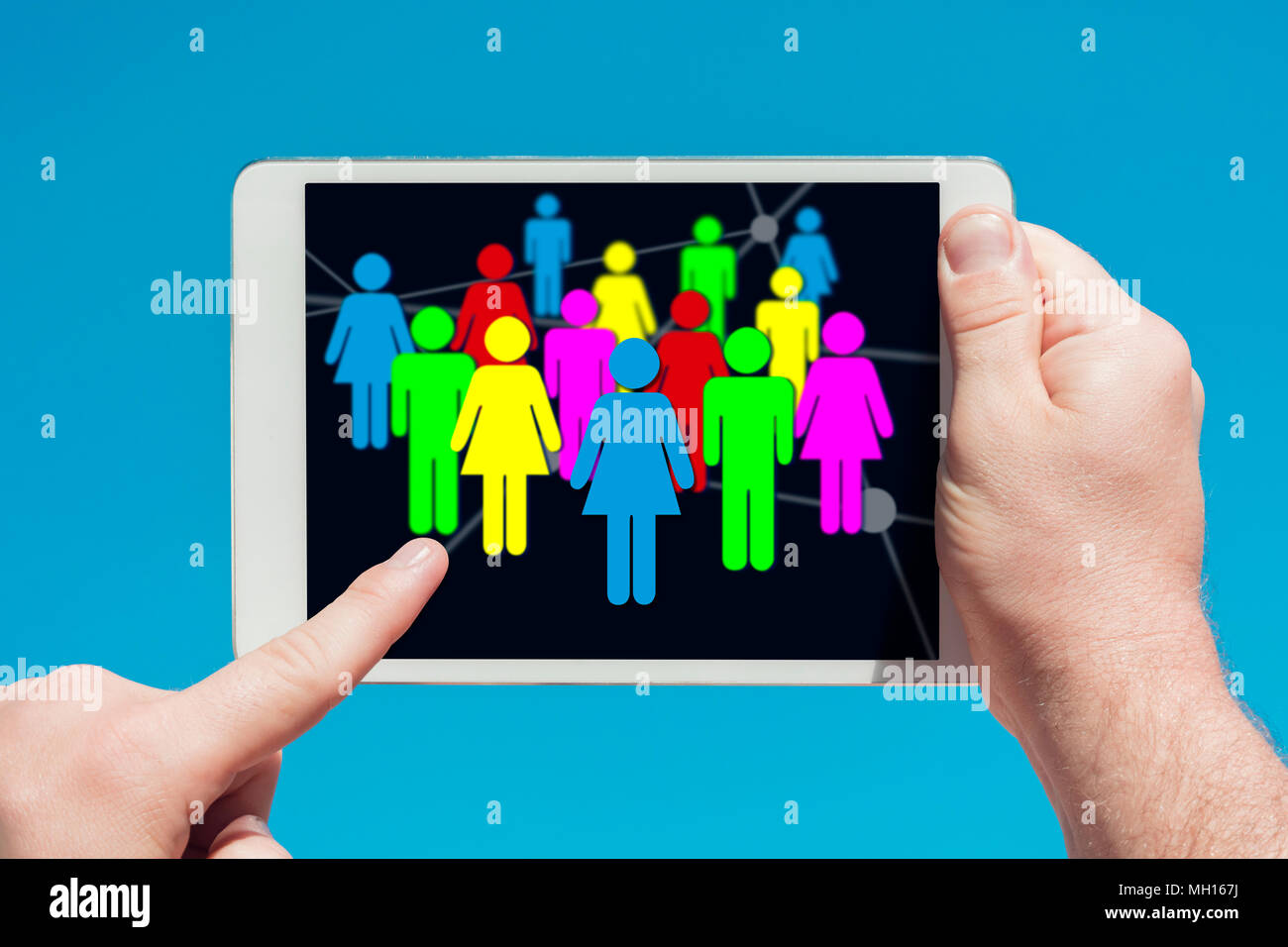 Uomo in possesso di un dispositivo tablet che mostra i social media e il concetto di comunicazioni, toccando lo schermo con un dito con il blu del cielo in background Foto Stock