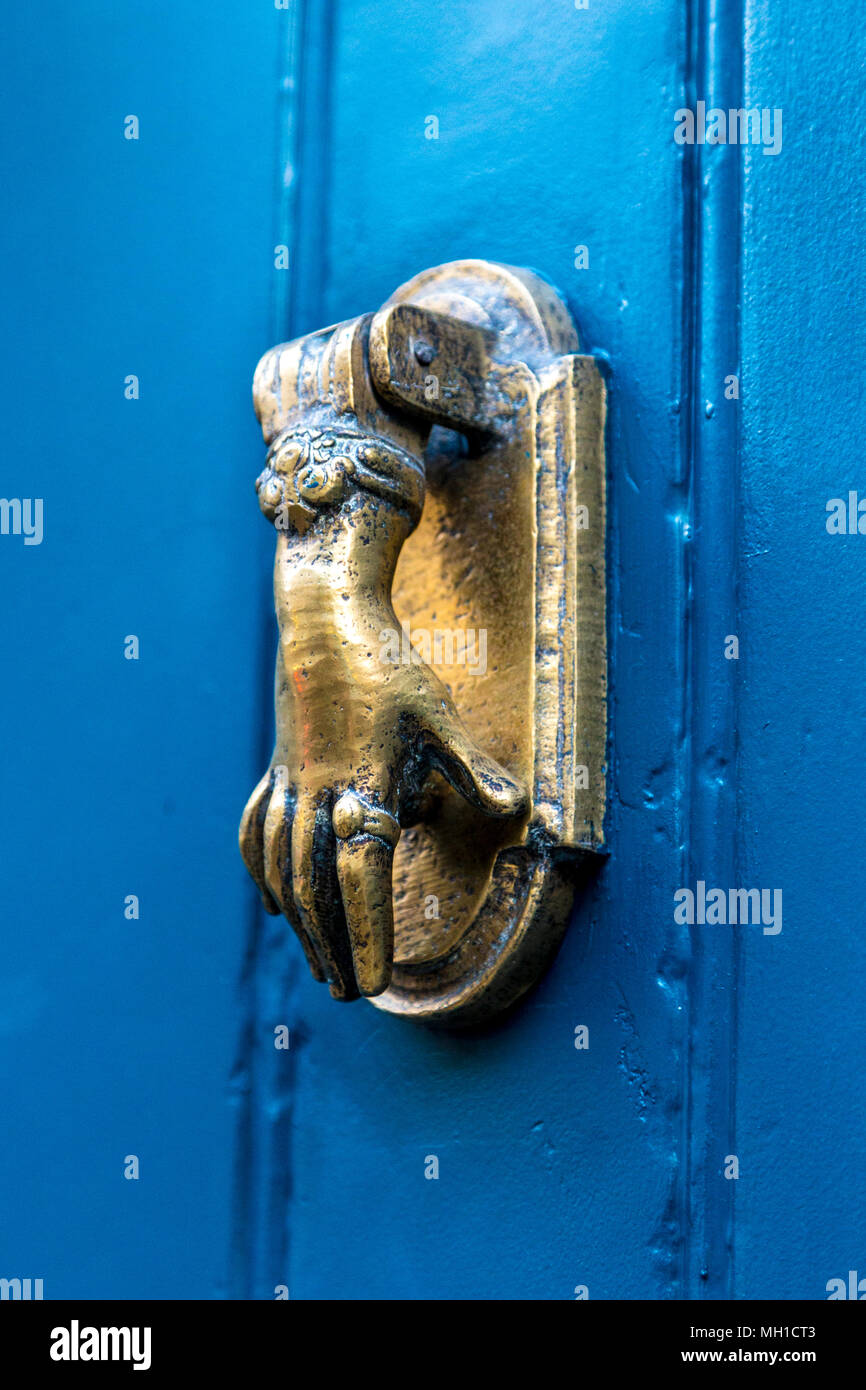 Un respingente porta la forma di una mano su di una porta blu, London, Regno Unito Foto Stock