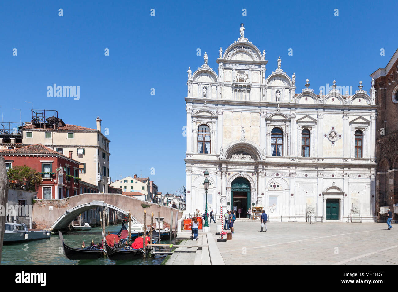 Scuola Grende di San Marco, Campo Santi Giovanni e Paolo, Castello, Venezia, Veneto, Italia con gondole nella parte anteriore del ponte Cavallo. Ora un hospita civica Foto Stock