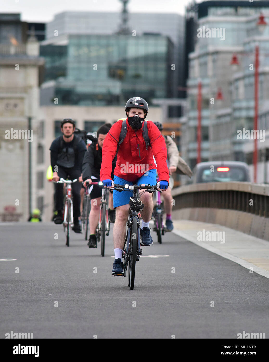 I ciclisti giro attraverso il Blackfriars Bridge in direzione sud, indossa una maschera sulla superstrada in bicicletta nel centro di Londra durante la mattina ora di punta. Foto Stock