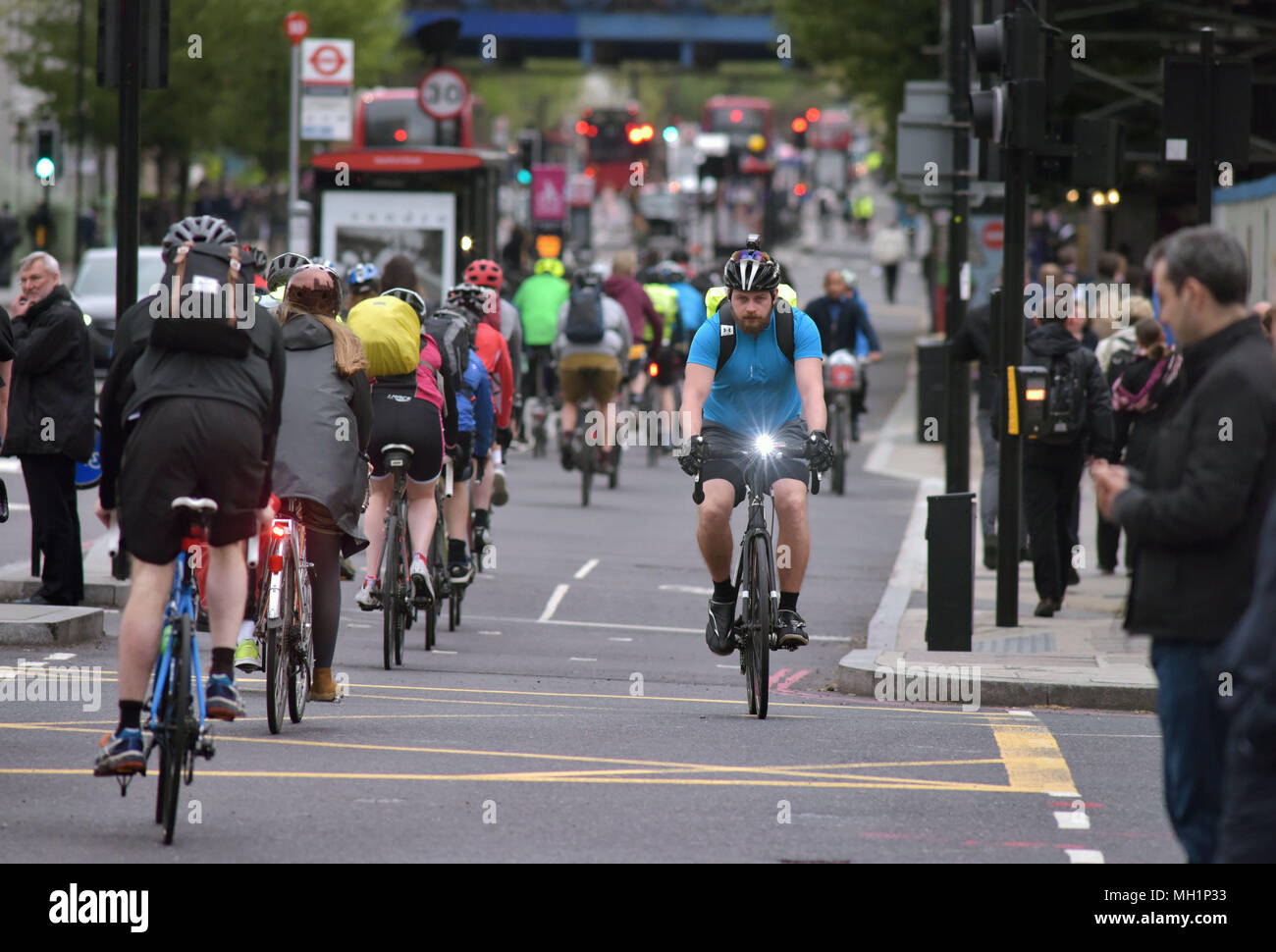 I ciclisti corrono lungo le due corsie autostradali in bicicletta su Blackfriars Bridge che conduce nella giunzione con Stamford Street nel centro di Londra durante il th Foto Stock