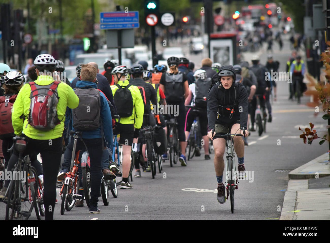 I ciclisti corrono lungo le due corsie autostradali in bicicletta su Blackfriars Bridge che conduce nella giunzione con Stamford Street nel centro di Londra durante il th Foto Stock
