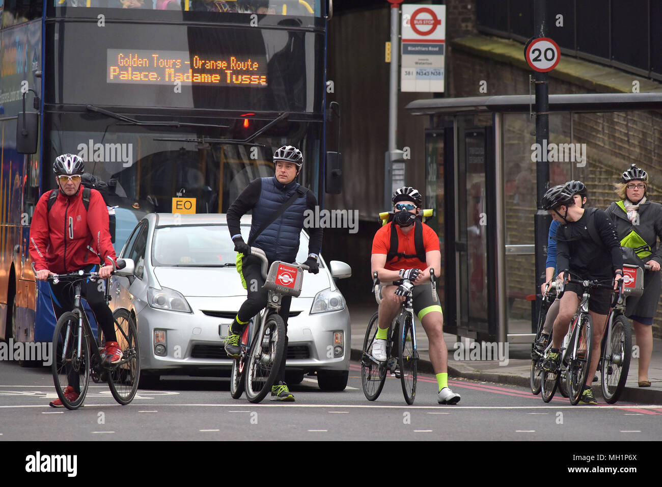 Un ciclista attende al bivio sulla Blackfrairs Bridge Road in sella a una moto di Santander in centro a Londra durante la mattina ora di punta Foto Stock