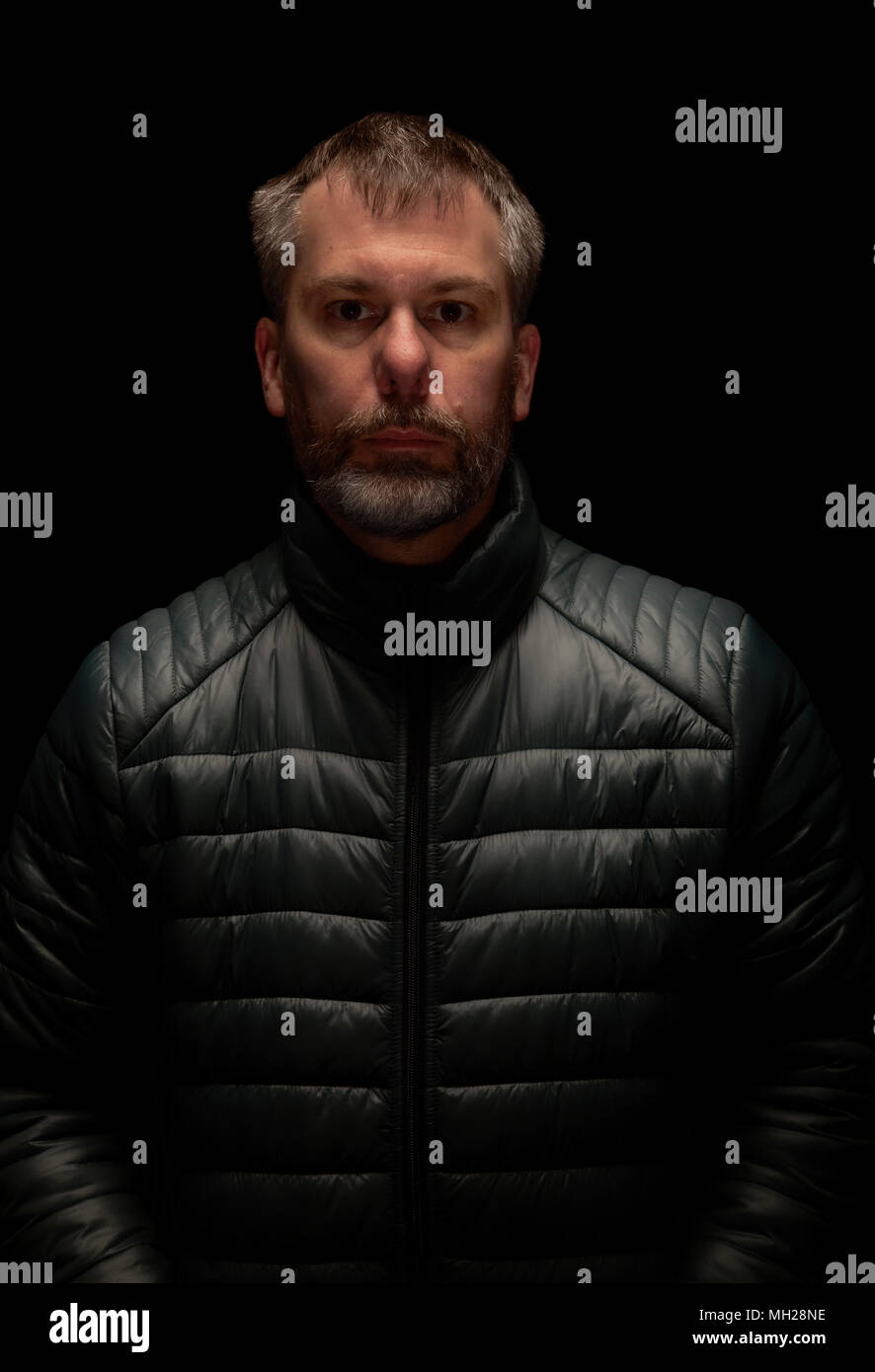 Uomo che indossa puffer giacca con una suggestiva illuminazione. Foto Stock