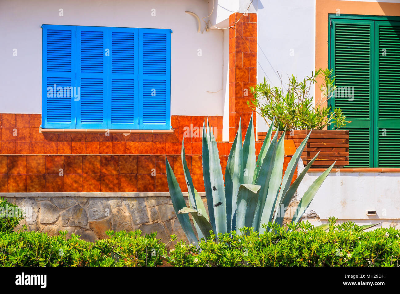 La facciata della tipica casa colorata nel piccolo villaggio sulla costa dell'isola di Maiorca vicino a Cala Ratjada, Spagna Foto Stock