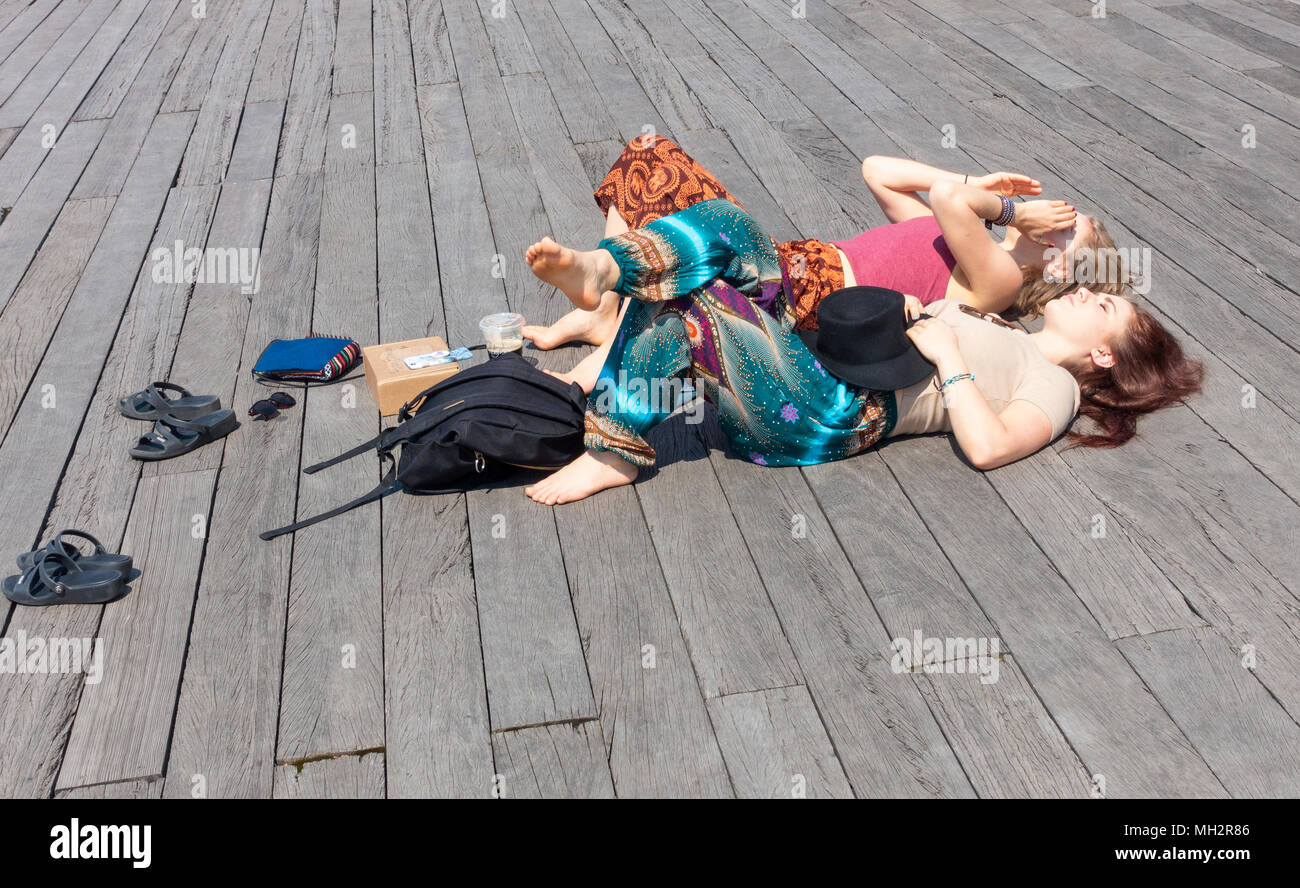 Due belle giovani donne che prendono il sole sul molo 1 in Dumbo Brooklyn Foto Stock