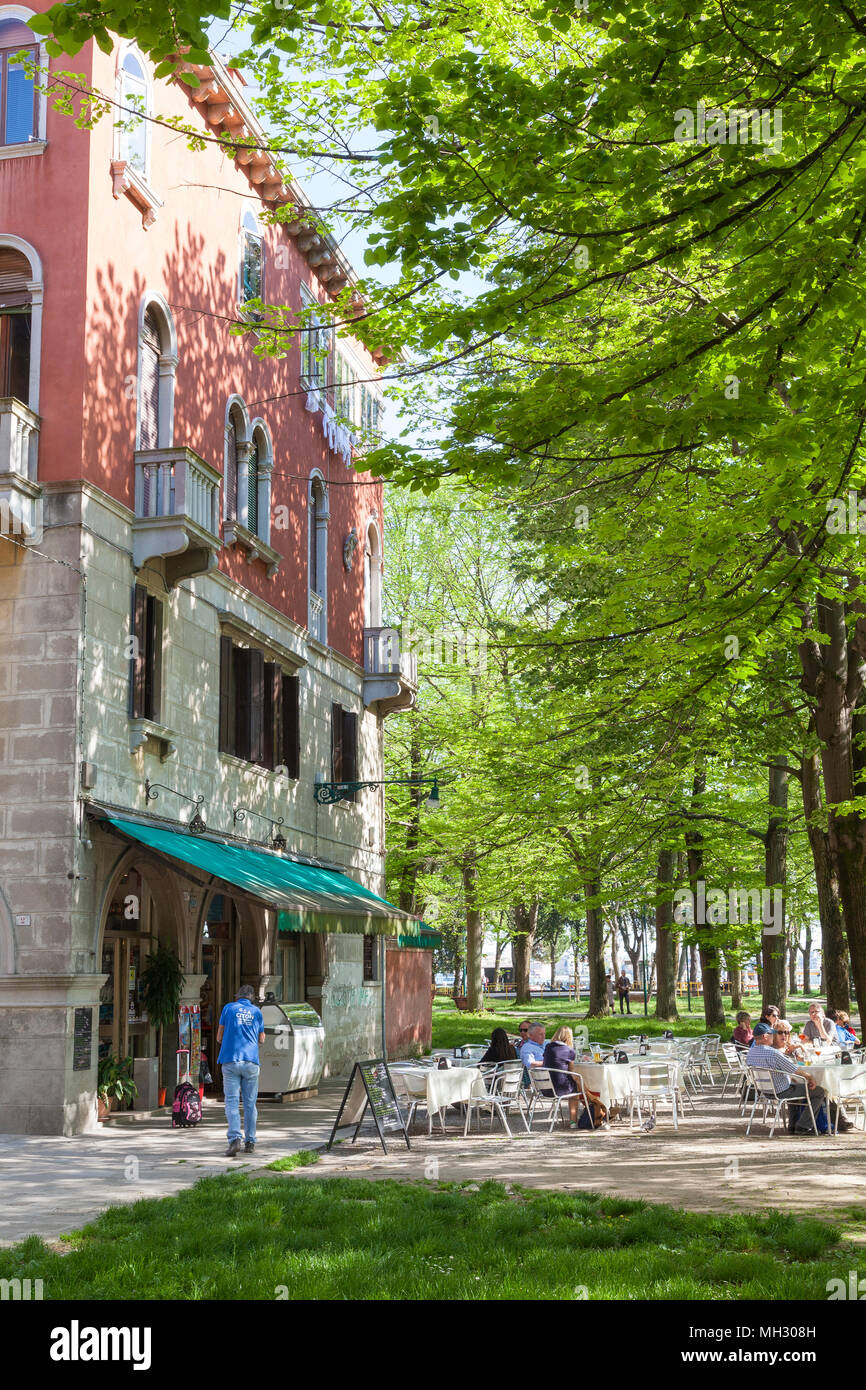 Primavera a Venezia. Fresco verde di alberi nel Parco della Rimembranze lungo Viale 1V Novembre, Sant'Elena, Venezia, Veneto, Italia, aria aperta retsaurant Foto Stock