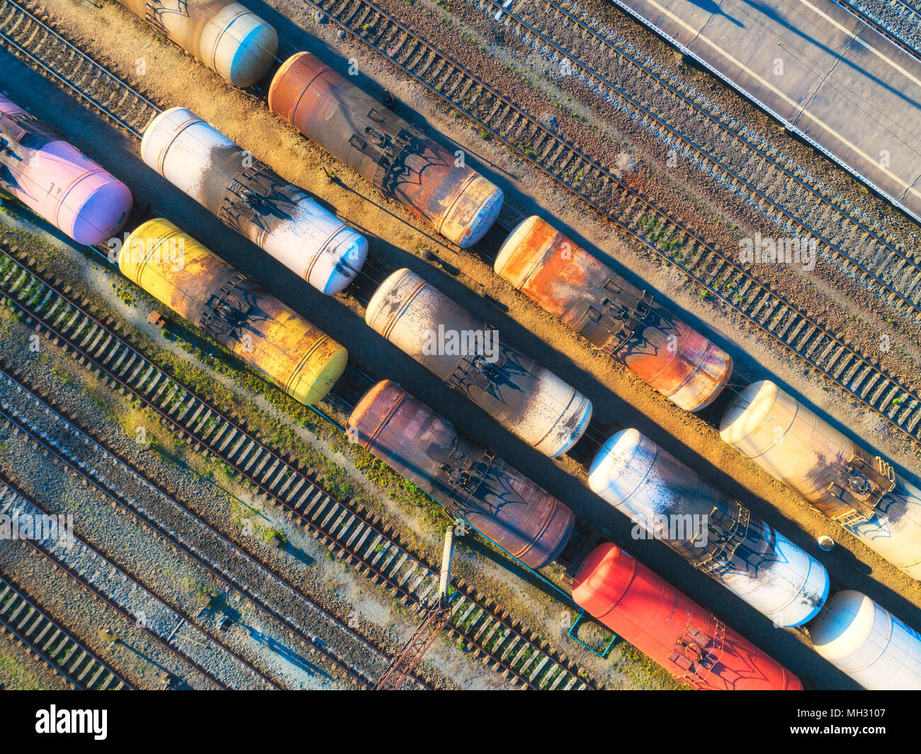 Vista aerea di coloratissimi treni merci sulla stazione ferroviaria. I treni merci di close-up. Vecchi carri con merci su ferrovia. Industria pesante. Cooperazione industriale Foto Stock