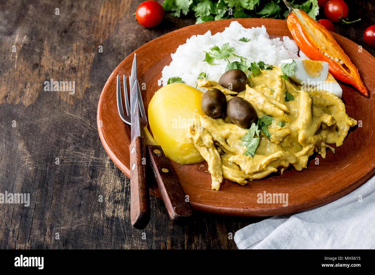 Messicane e cucina peruviana. Aji de gallina. Pollo aji de gallina con uova di olive e di riso sulla piastra di argilla. Tipico peruviano e piatto messicano. Foto Stock