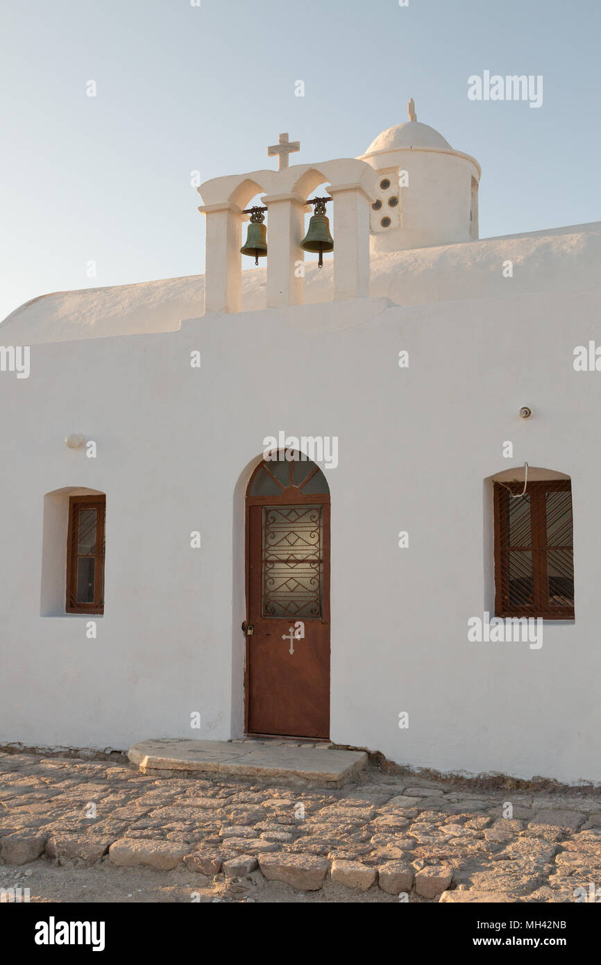 Bianco chiesa lavato con red porta ad arco sulla isola di Milos in Grecia Foto Stock