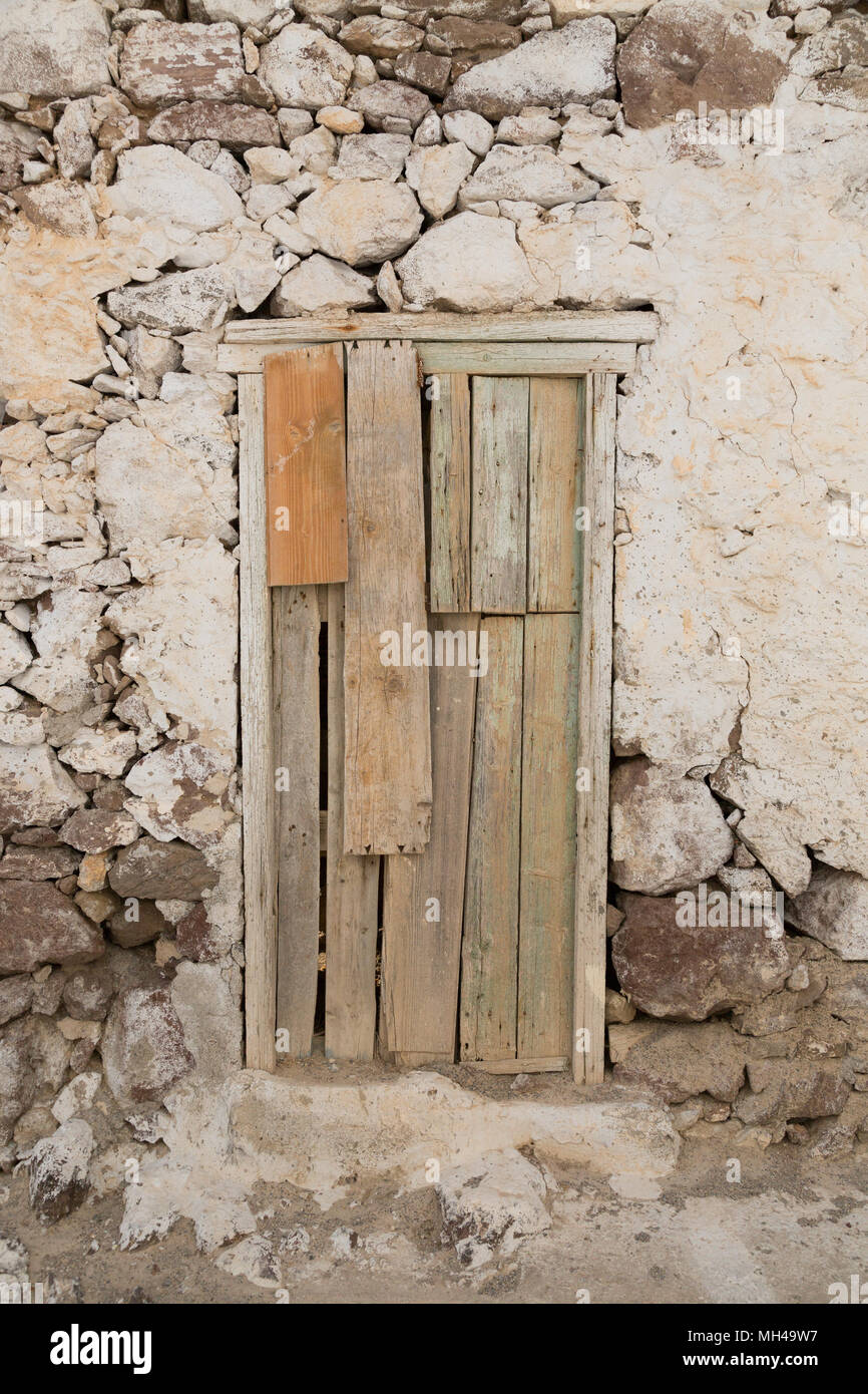 Vecchio sbriciolamento rock house con porte in legno Foto Stock