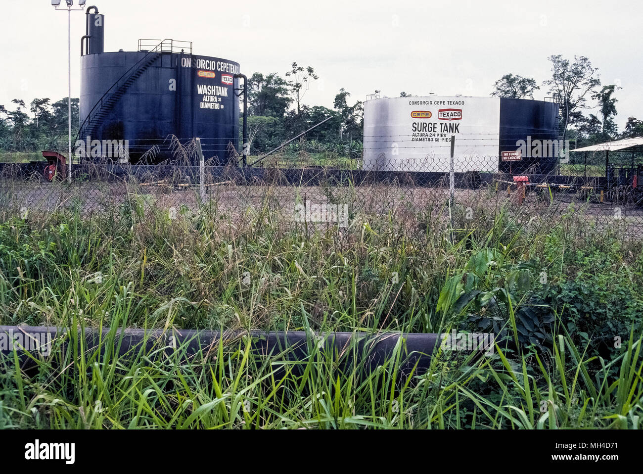 Un oleodotto e lavaggio e picchi di serbatoi di olio in Ecuador, Sud America, sono la prova di intrusione da parte della industria del petrolio nel Oriente jungle regione del Rio delle Amazzoni. La scoperta di petrolio greggio vi negli anni Sessanta da American oil company Texaco ha portato ambientale e culturale per la distruzione della foresta pluviale incontaminata e la vita dei popoli indigeni. Cause legali da allora sono stati portati contro la Chevron, Texaco suo successore, per pulire la contaminazione del terreno e dei fiumi provocato dalle fuoriuscite di petrolio e di sostanze tossiche di acque di scarico che hanno portato problemi cronici di salute per la popolazione autoctona. Foto Stock