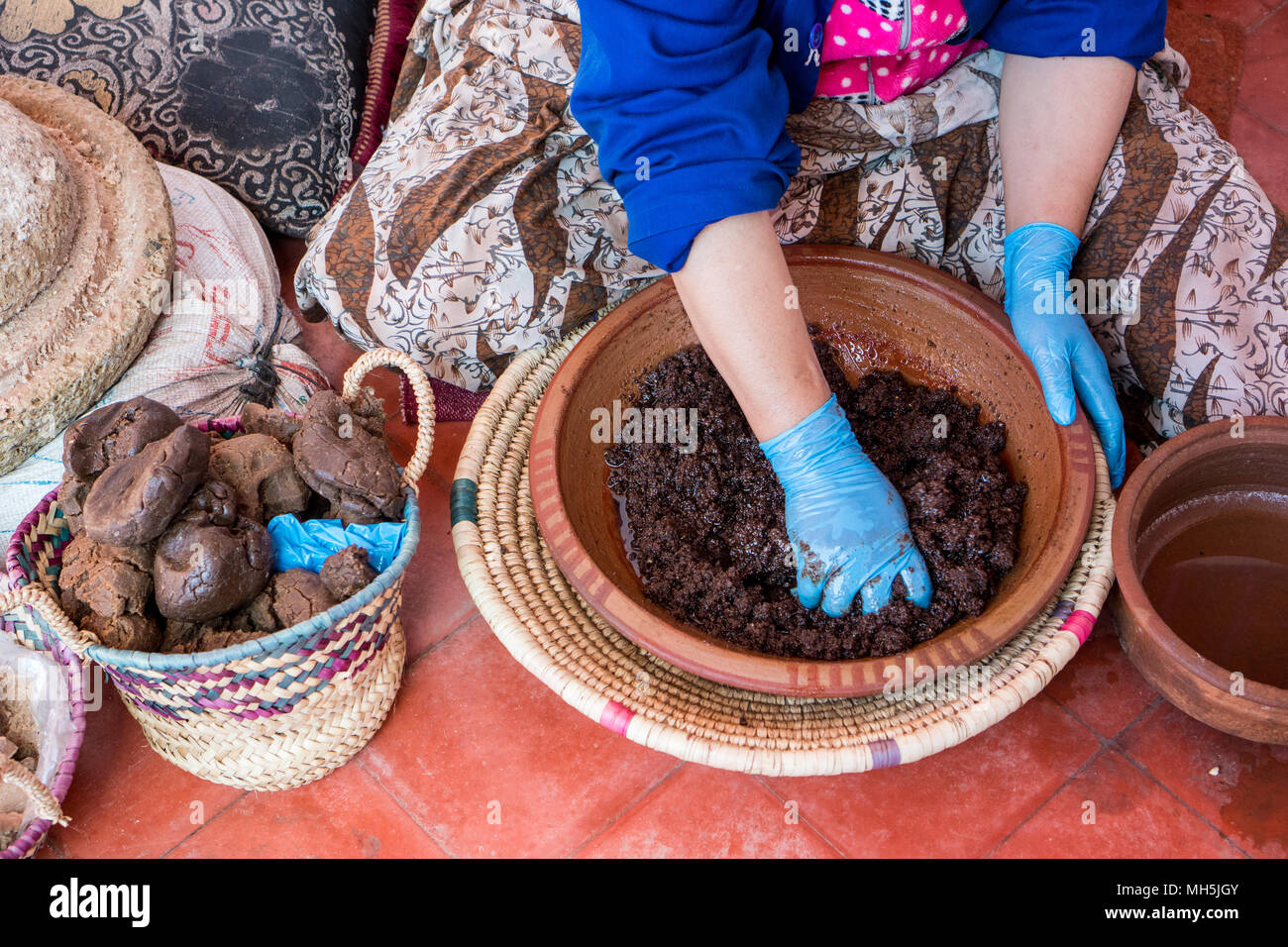 Le donne musulmane rendendo l'olio di argan in modo tradizionale in Marocco. La produzione tradizionale di olio di argan utilizzato per i prodotti cosmetici e per la preparazione dei prodotti alimentari Foto Stock
