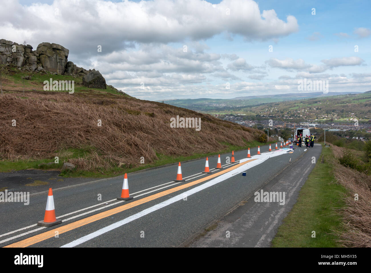 Ilkley Moor, West Yorkshire, Regno Unito. Il 30 aprile 2018. Artisti in appoggio le loro ginocchia dopo aver trascorso ore dipinto il Tour de Yorkshire il primo vertice finish sulla mucca e vitello strada pronti per il venerdì di gara. Che cosa sta andando essere? (Anamorfico land art) Rebecca Cole/Alamy Live News Foto Stock