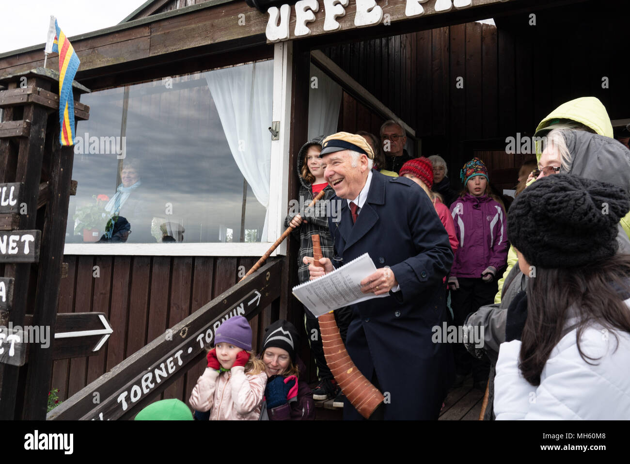 Arcipelago delle Isole Åland, Finlandia, 30 aprile 2018 persone indossano i loro cappelli di graduazione, cantare vecchie canzoni e costruire i falò in tutta la Finlandia e i paesi nordici per dire addio all'inverno e benvenuto in primavera. Nella foto: Le corna vengono soffiati a usher fuori stagione invernale e usher in primavera sulla roccia di Uffe På Berget sulle isole Åland. Immagine: Rob Watkins/Alamy News Foto Stock